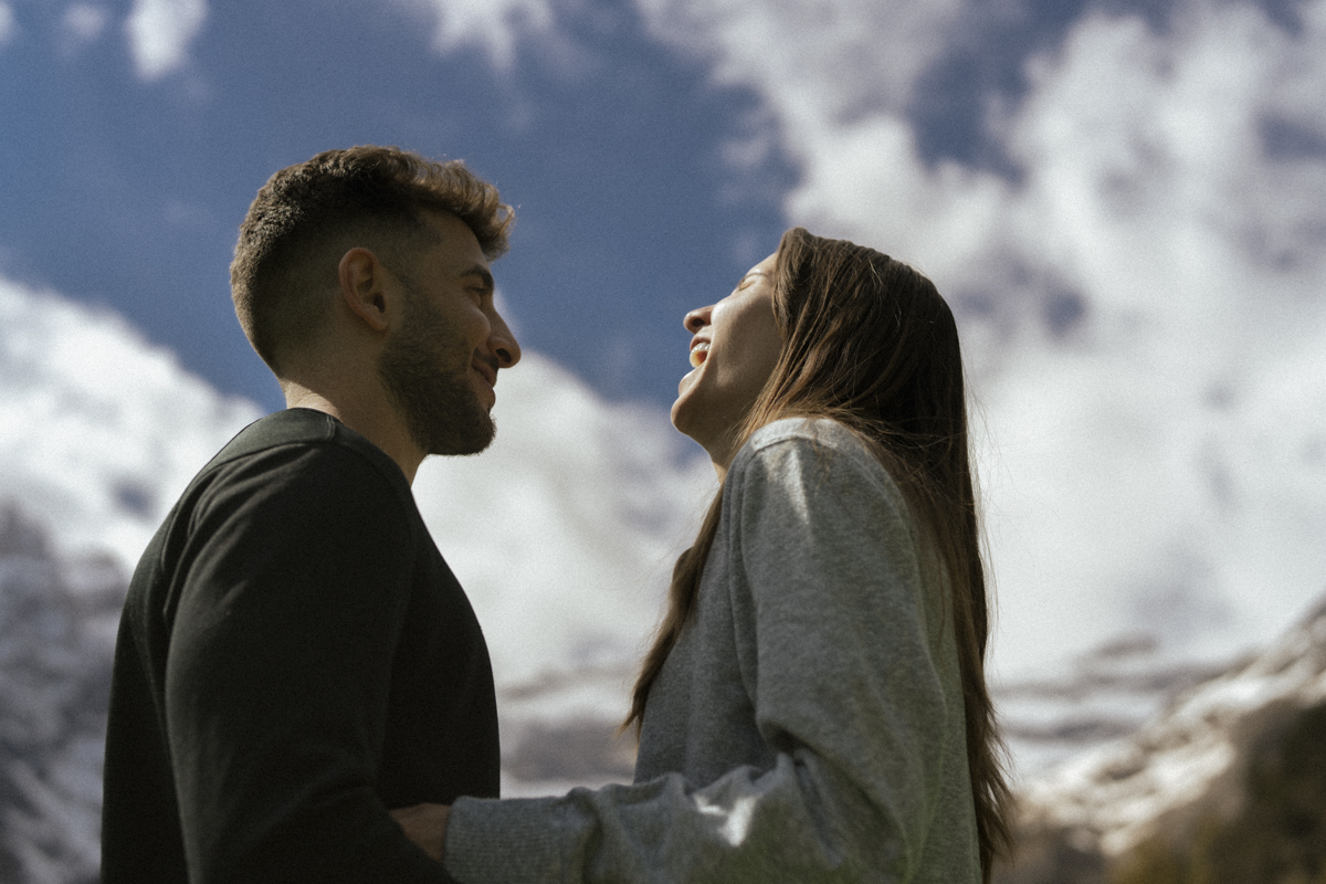 séance engagement d'un couple d'américains du colorado au pied du irque de gavarnie dans les hautes pyrénées. Le couple est face à face et ri aux éclats.