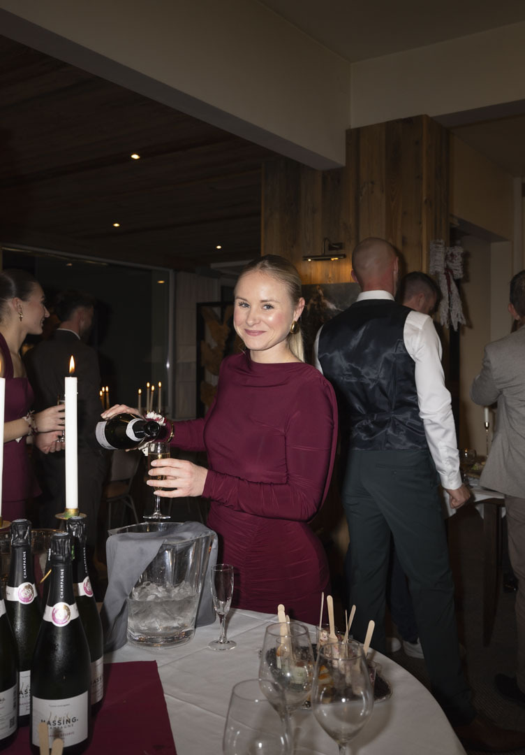 Invitée élégante se servant une coupe de champagne lors du cocktail à l'hôtel Le Christiania, St-Lary Soulan, Hautes Pyrénées